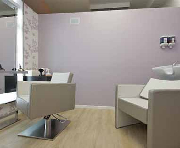 Una cabina di trattamento con specchio e poltrona