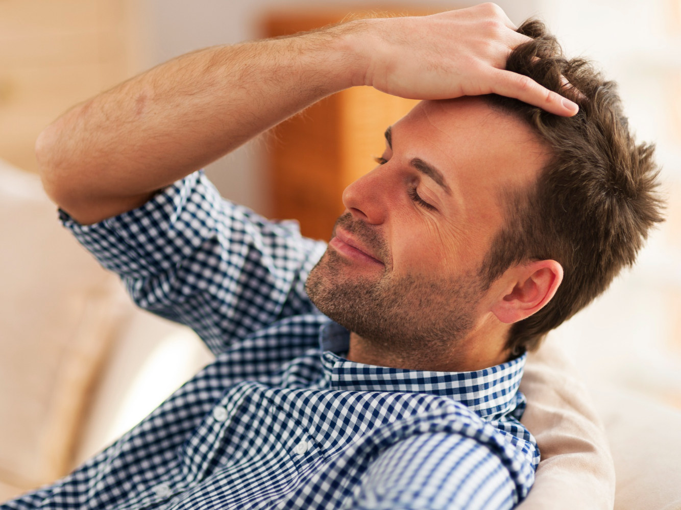 Un uomo disteso si passa una mano fra i capelli