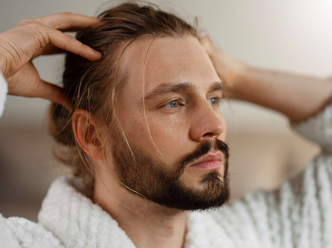 Un uomo si passa le mani fra i capelli lunghi