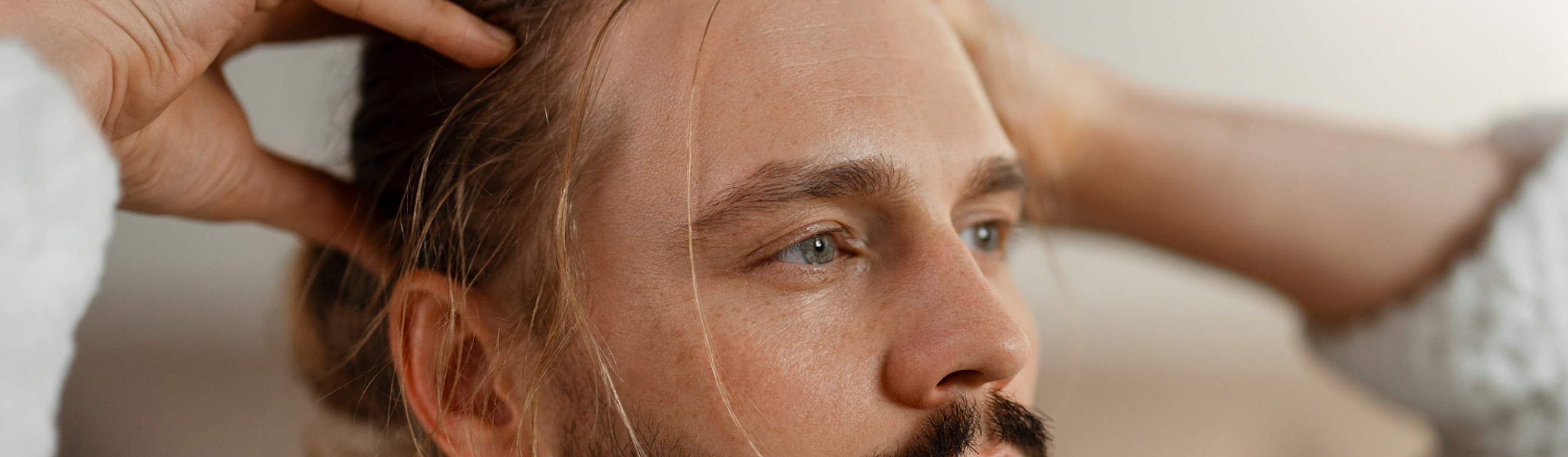 Un uomo si passa le mani fra i capelli lunghi
